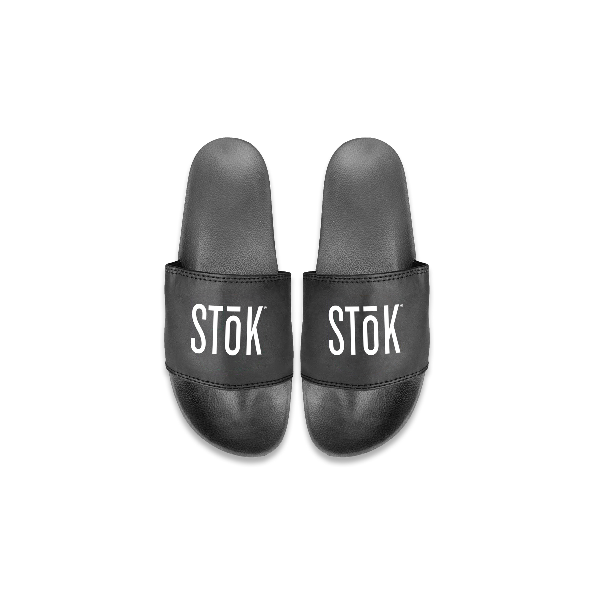 Black rubber slides with the white Stōk logo written across the strap of both.