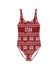 The front of a red one piece swimsuit with a knitted pattern design featuring white snowflakes and geometric shapes throughout. The Stōk logo is displayed in white on the front across the chest, maintaining a clean and simple contrast against the intricate design.